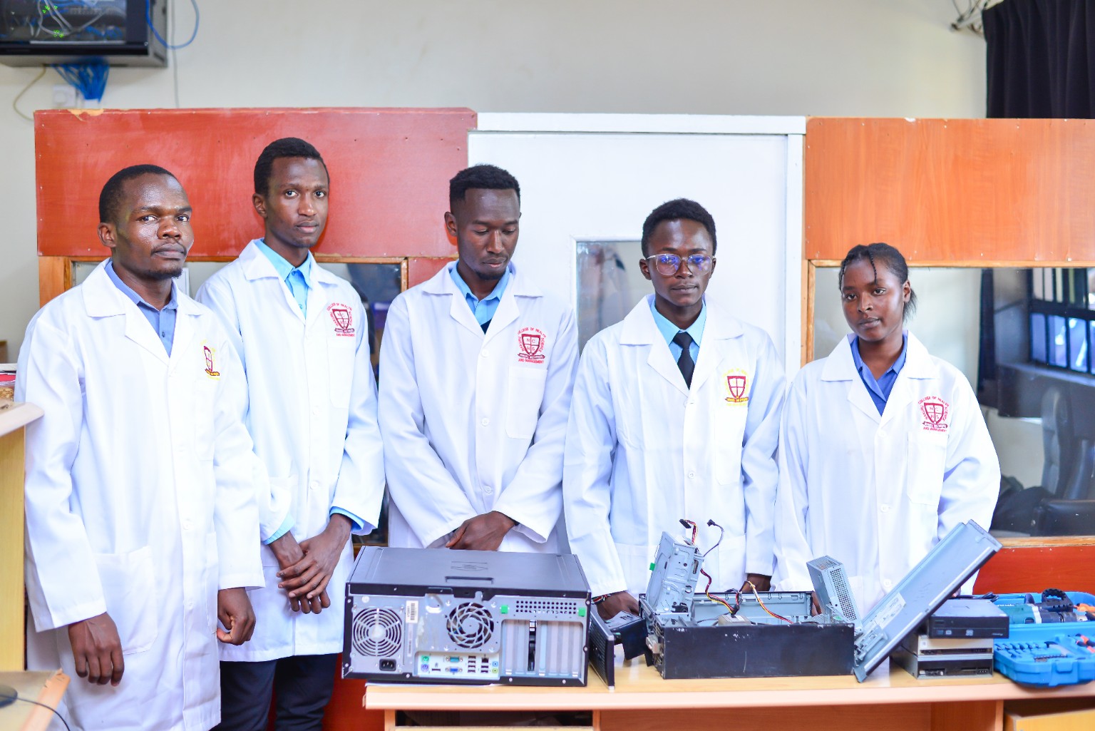Students working with computer hardware in a practical learning setting