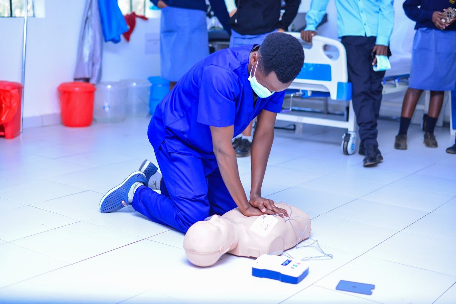Nursing student practising CPR on a training mannequin in the skills lab